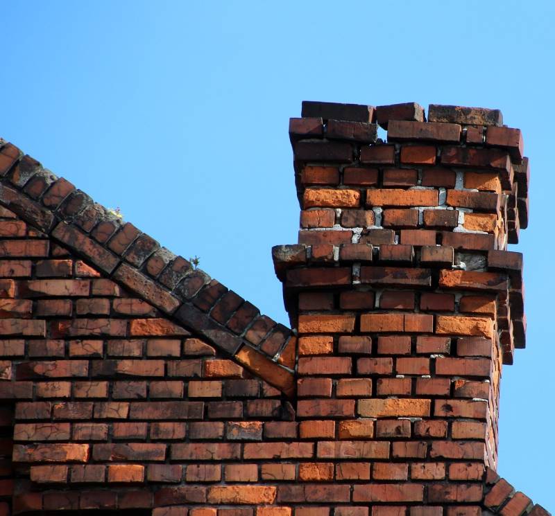 Damaged chimney on an Fork home showing cracks and missing mortar